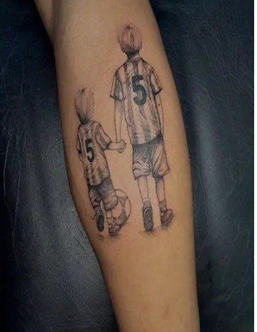 Padre e hijo con camiseta número 5 tatuados en el antebrazo