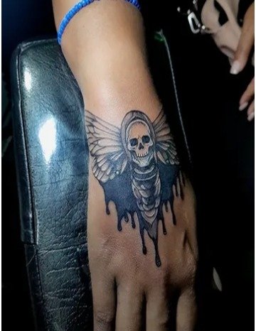 Calavera con alas y sombreado sólido en la mano