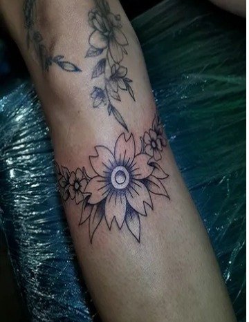 Girasol y enredadera floral en línea fina en el antebrazo
